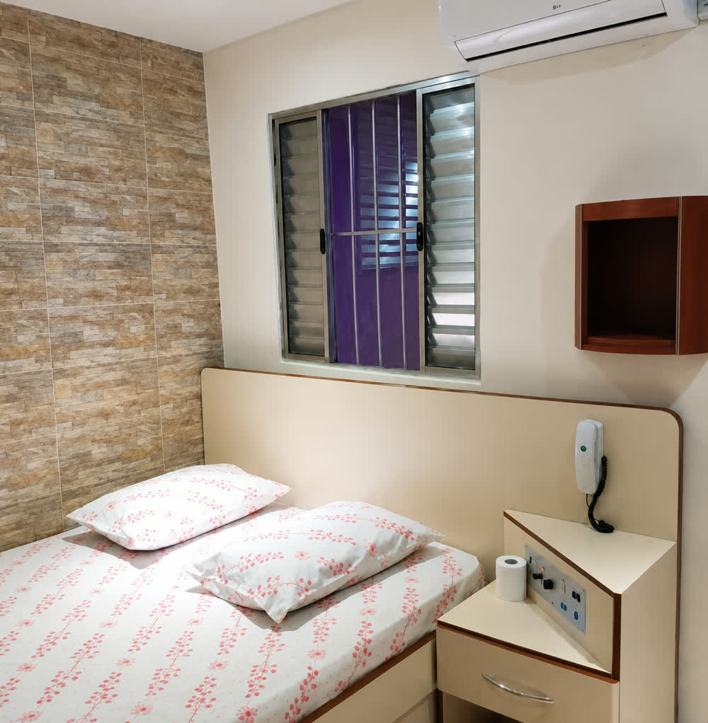 Quarto com camas de solteiro, toalhas e criado-mudo